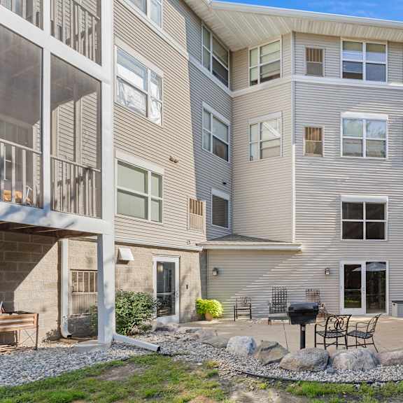 a modern apartment building with a patio and outdoor furniture.