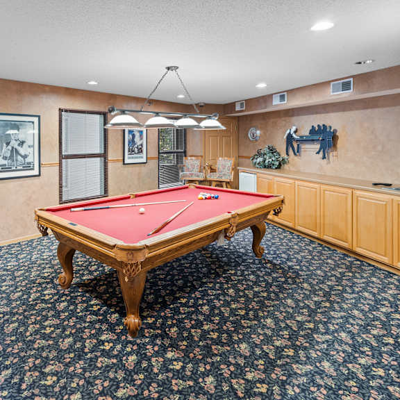 a pool table in a room with a blue carpet.