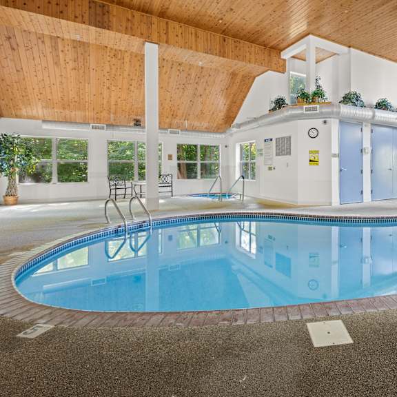 a large indoor swimming pool with a wooden ceiling.