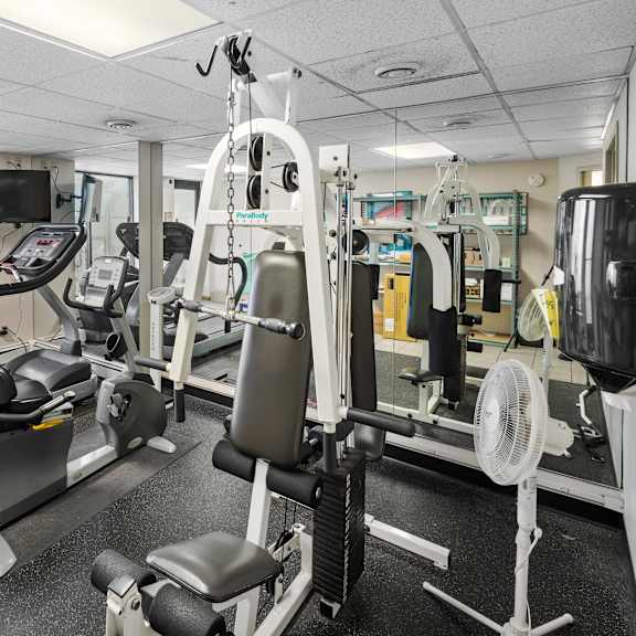 a gym with treadmills, weights, and exercise equipment.