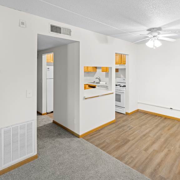 a kitchen with white cabinets and a wooden floor.