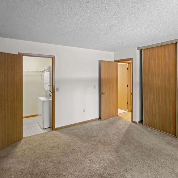 a room with carpeted floor and wooden doors.