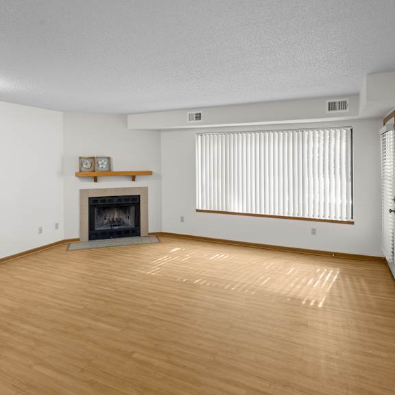 a living room with a fireplace and a wooden floor.