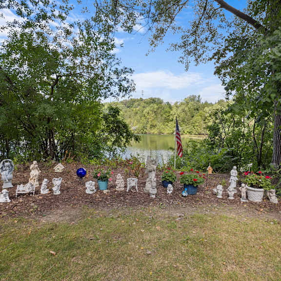 a garden with a flag and a lake in the background.