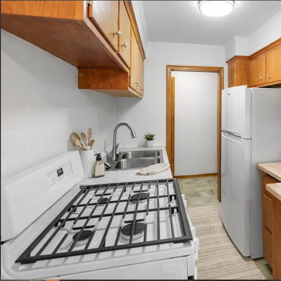 a kitchen with a white stove top oven and a white refrigerator.