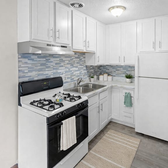 a kitchen with white cabinets and a black stove top oven.