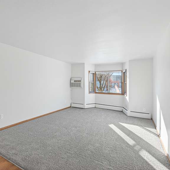a room with a grey carpet and a wooden door.