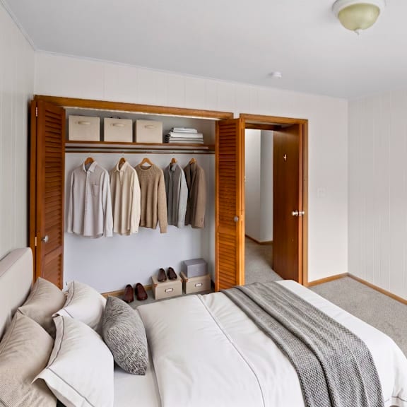a bedroom with a large bed and a wooden wardrobe.