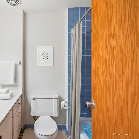 a white toilet with a towel bar and a white sink with a mirror above it.