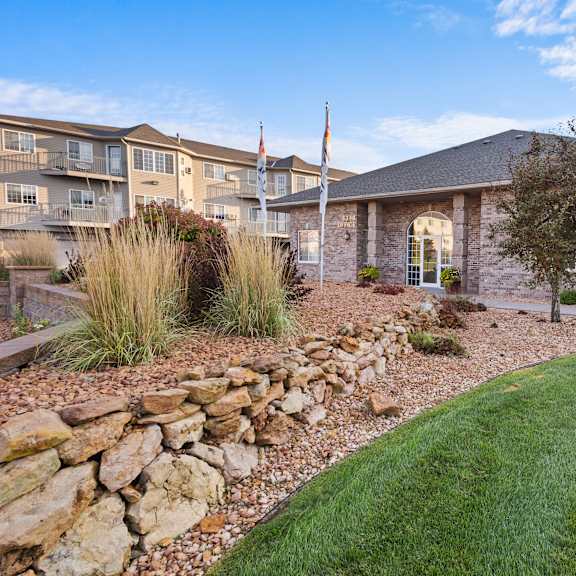a house with a stone wall in front of it.