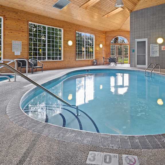 a round indoor swimming pool with a glass wall surrounding it.