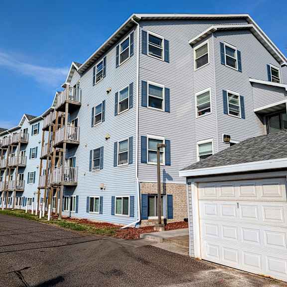 a gray apartment building with a white garage door