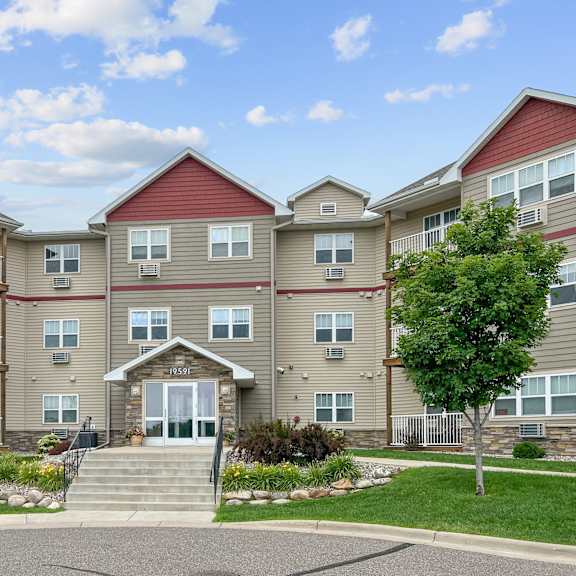 a large apartment complex with a front entrance and landscaping.