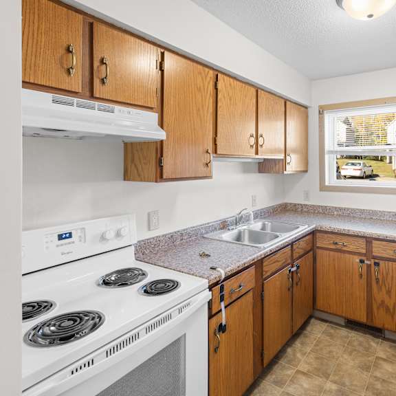 a kitchen with white appliances and wooden cabinets.