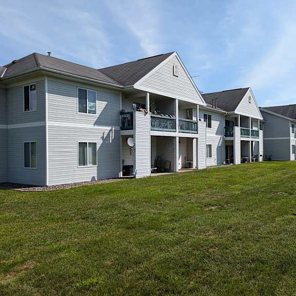 a row of houses on a hill with a grass field