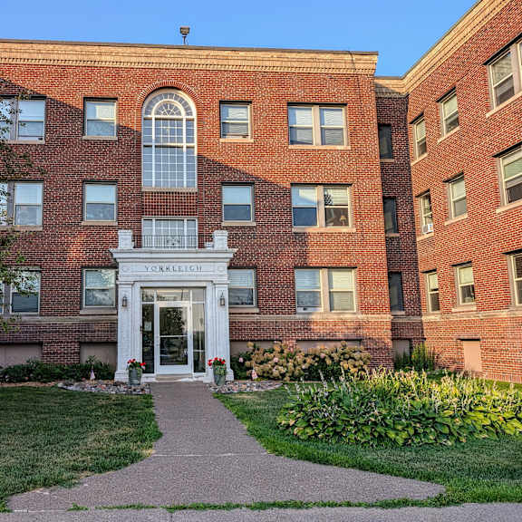 a large brick building with a sidewalk in front of it