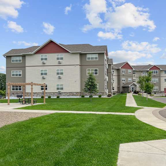 apartment complex with a green lawn in front.