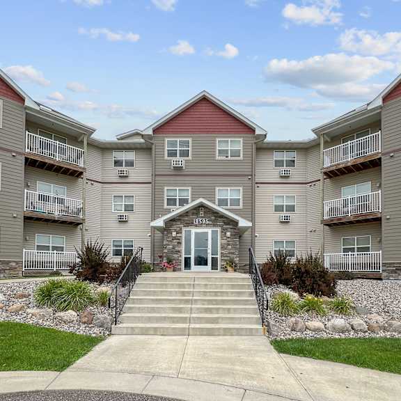 a building with a red roof and a front entrance with steps leading up to it.
