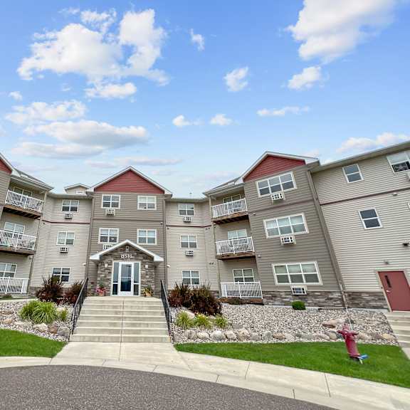 a large apartment complex with a red fire hydrant in front.