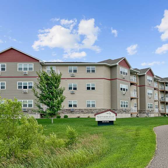 a building with a sign that says "apartment homes" in front of it.