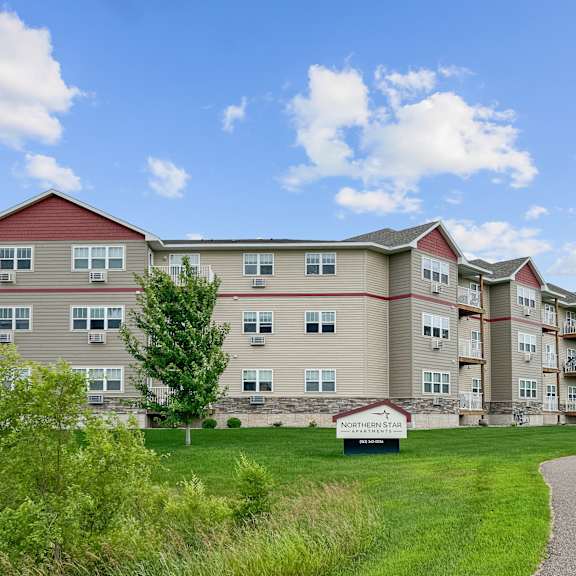 a large apartment complex named northern star is surrounded by green grass and trees.