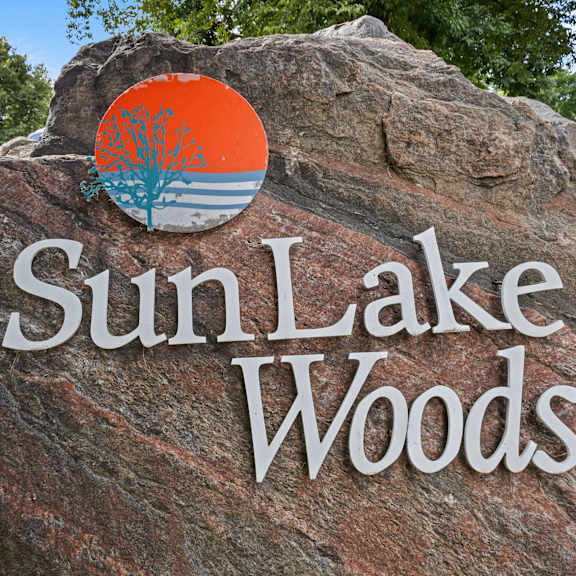a rock with the sun lake woods logo on it