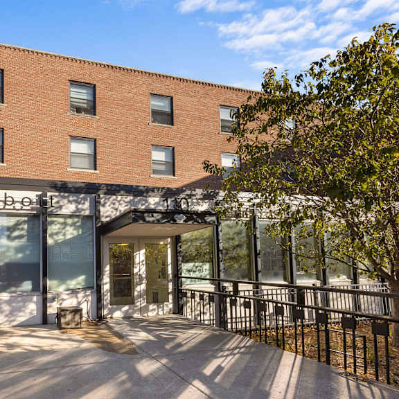 a large brick building with a patio and a bench
