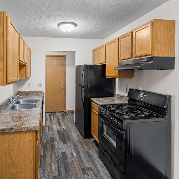 our apartments have a kitchen with black appliances and wooden cabinets