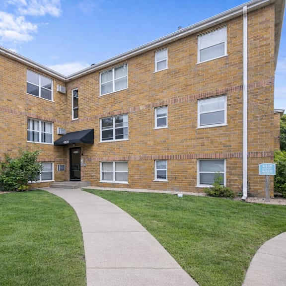 a brick building with a walkway in front.