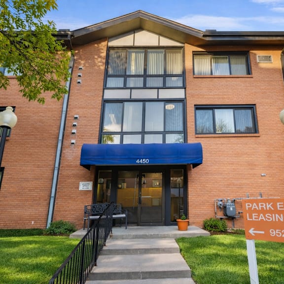 the image shows a brick building with a sign that reads "park embassy leasing office" and a phone number.