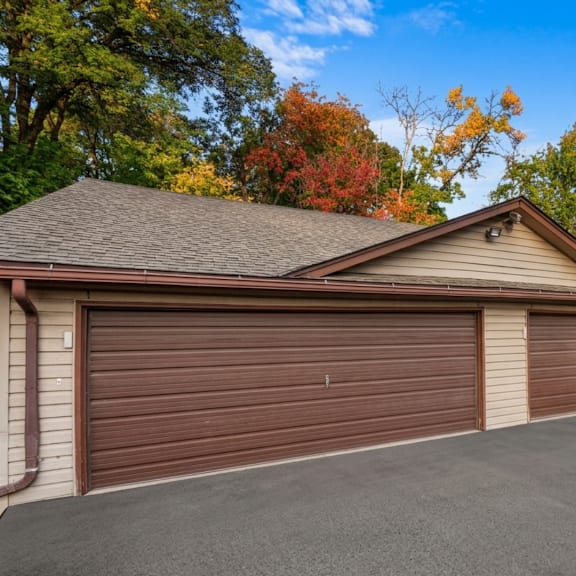 a house with a brown garage door and a grey roof.