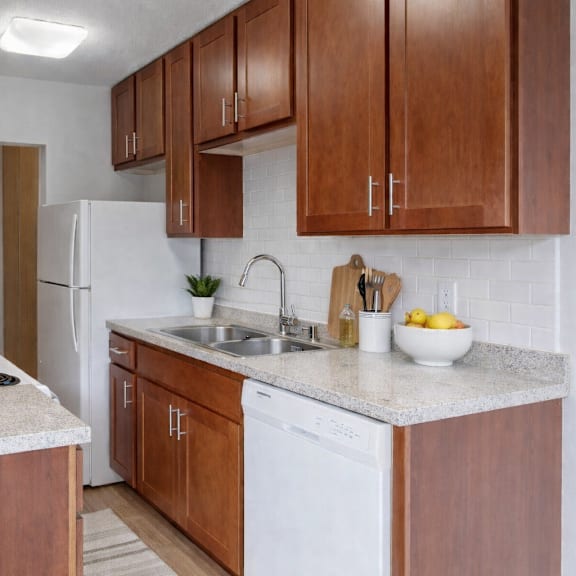 a kitchen with brown cabinets and a white fridge.