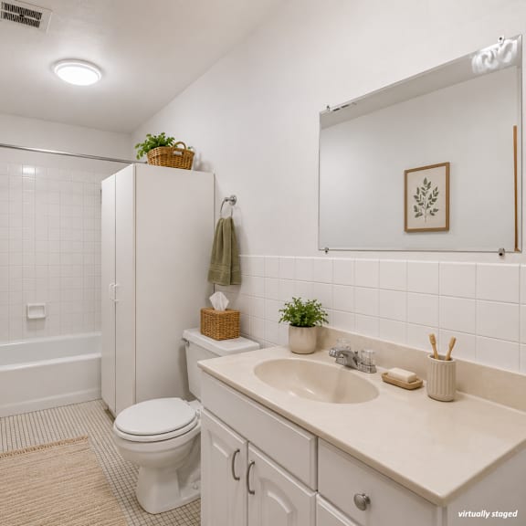 a bathroom with a toilet, sink, and shower.