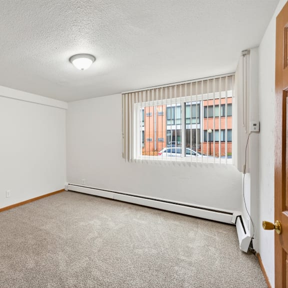 a room with a window and a carpeted floor.