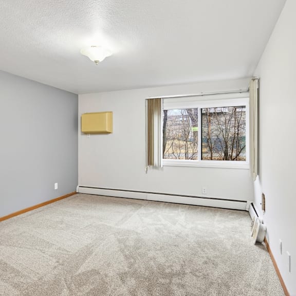 a room with a carpeted floor and a window.