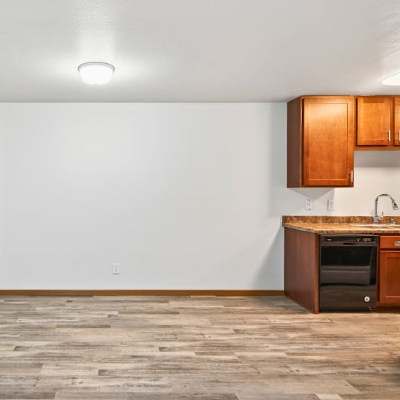 a kitchen area with a wooden floor and a small kitchenette.