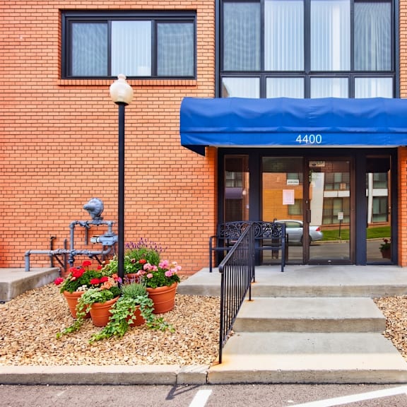 the entrance to a building with a blue awning and a sign that reads 4400.