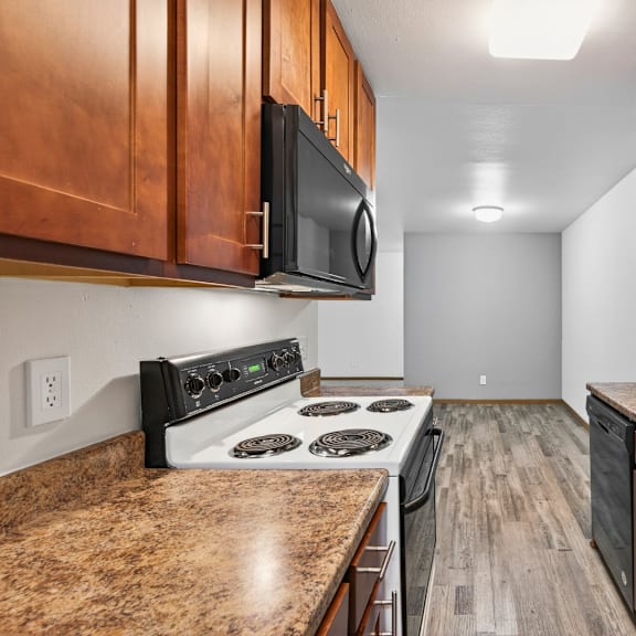 a kitchen with a stove, microwave, and sink.