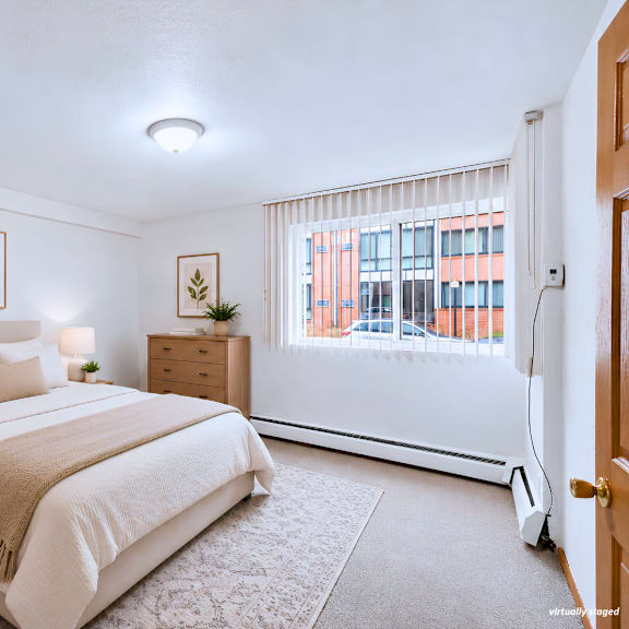 a bedroom with a large bed and a window with blinds.
