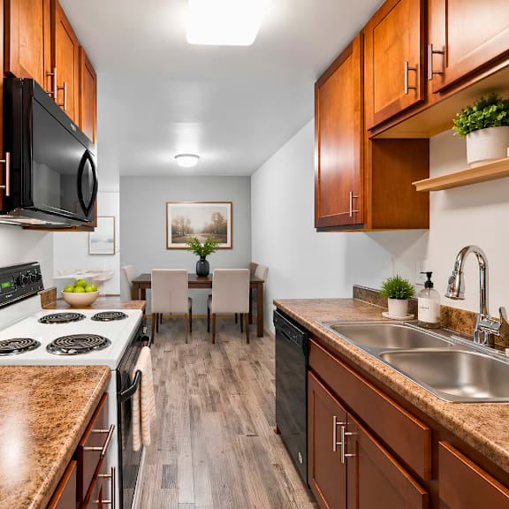 a kitchen with brown cabinets and a black stove top.