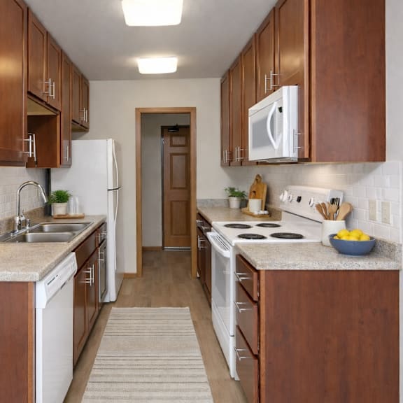 a kitchen with brown cabinets and white appliances.