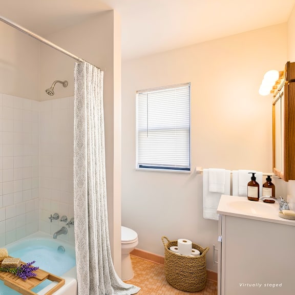 a bathroom with a shower curtain and a bathtub filled with blue water.