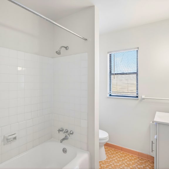 a white bathroom with a tub, toilet, and sink.