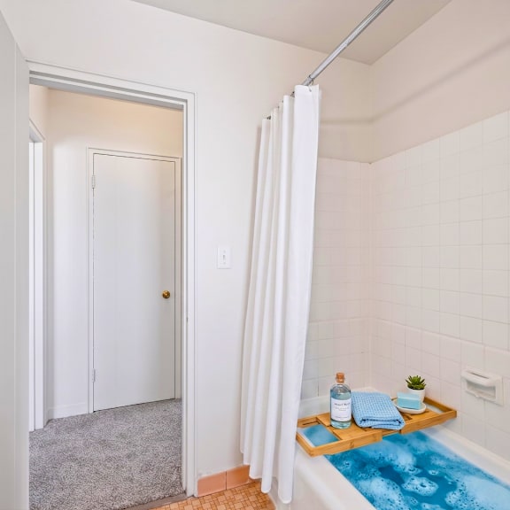 a bathroom with a white tub and a white shower curtain.