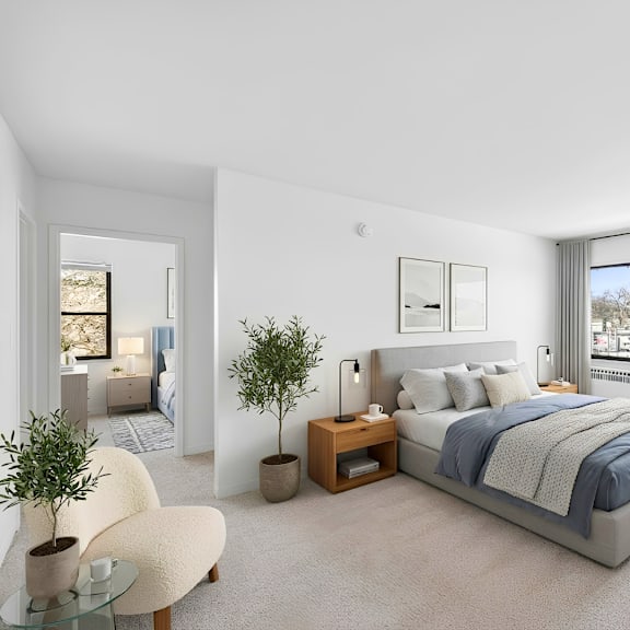 a bedroom with a large bed, a chair, and a plant.