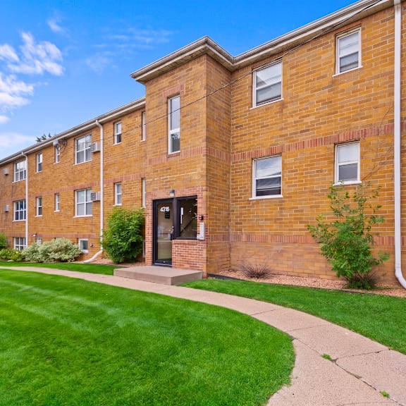 a brick building with a green lawn in front.
