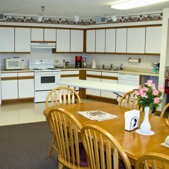 a kitchen with a table and chairs in front of it.