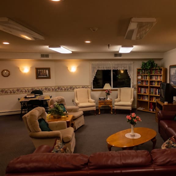 a living room with a brown leather couch and a round wooden table.