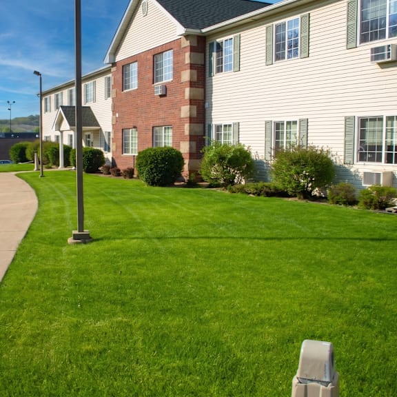 a grassy area in front of a building with a lamp post.