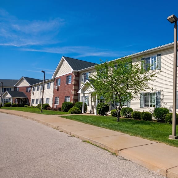 a row of houses with a sidewalk in front.